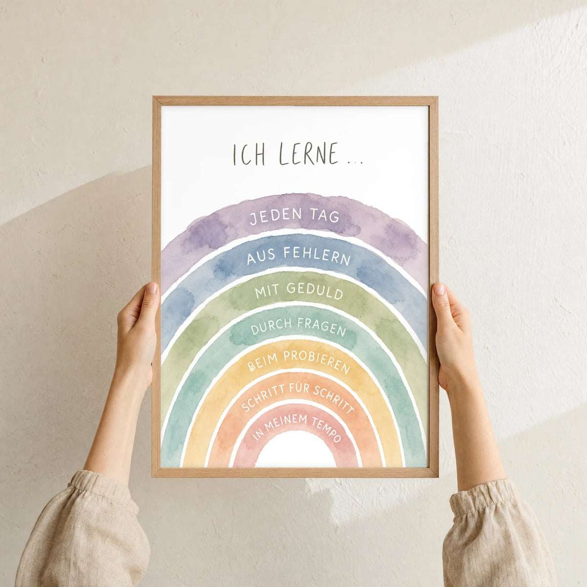 Affirmationsposter „Regenbogen Ich lerne“ im Holzrahmen in den Händen gehalten – Taufgeschenk und Kinderzimmer Deko