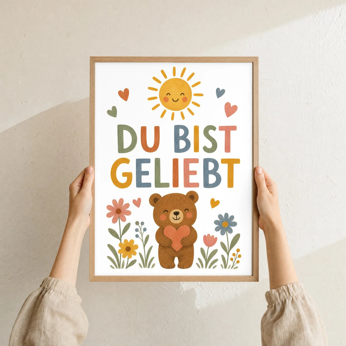 Affirmationsposter „Bär Du bist geliebt“ im Holzrahmen in den Händen gehalten – Taufgeschenk und Kinderzimmer Deko