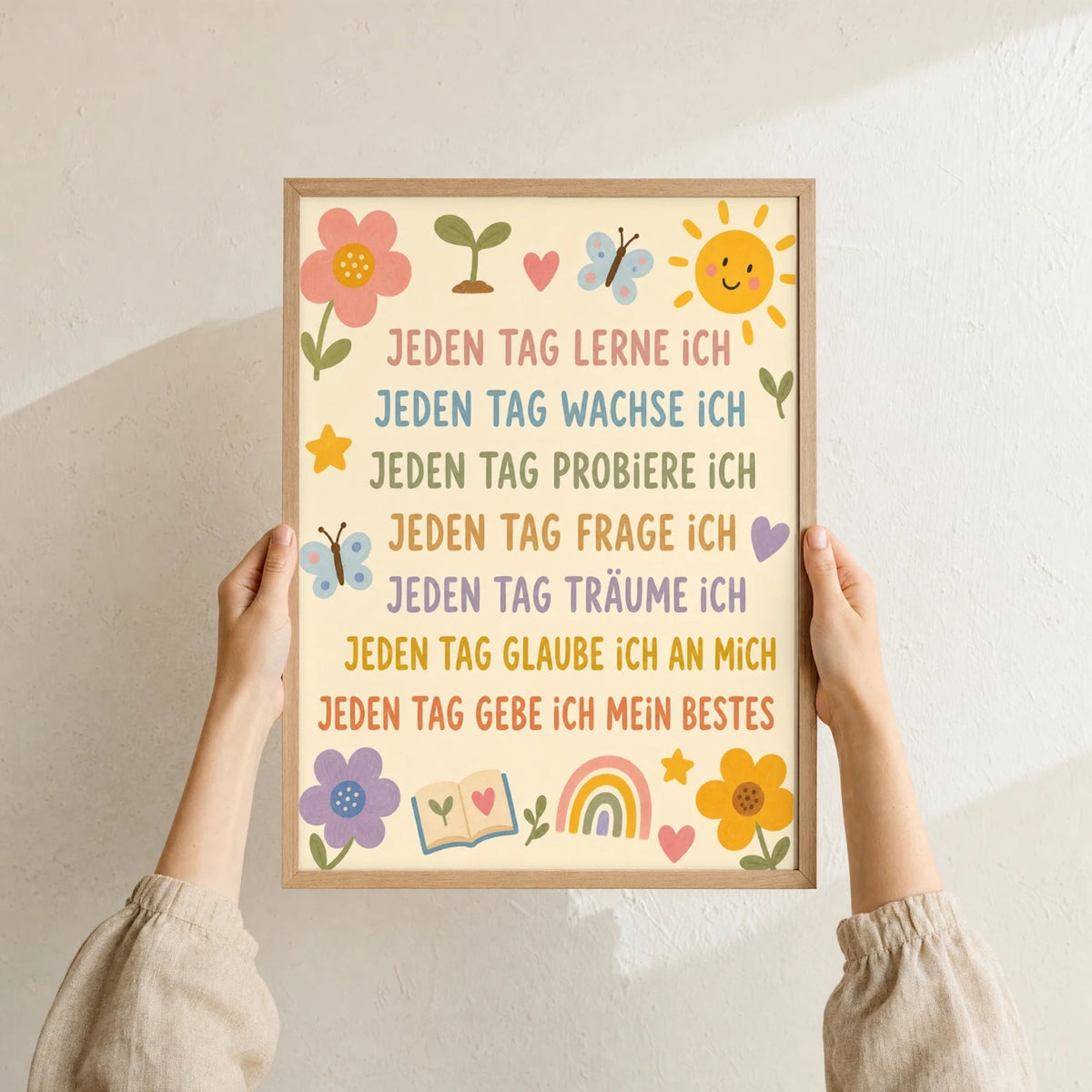 Affirmationsposter „Blumenwiese Jeden Tag“ im Holzrahmen in den Händen gehalten – Taufgeschenk und Kinderzimmer Deko