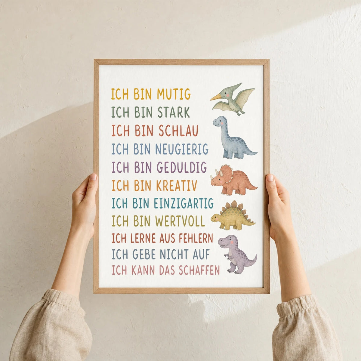 Affirmationsposter „Dinos“ im Holzrahmen in den Händen gehalten – Taufgeschenk und Kinderzimmer Deko