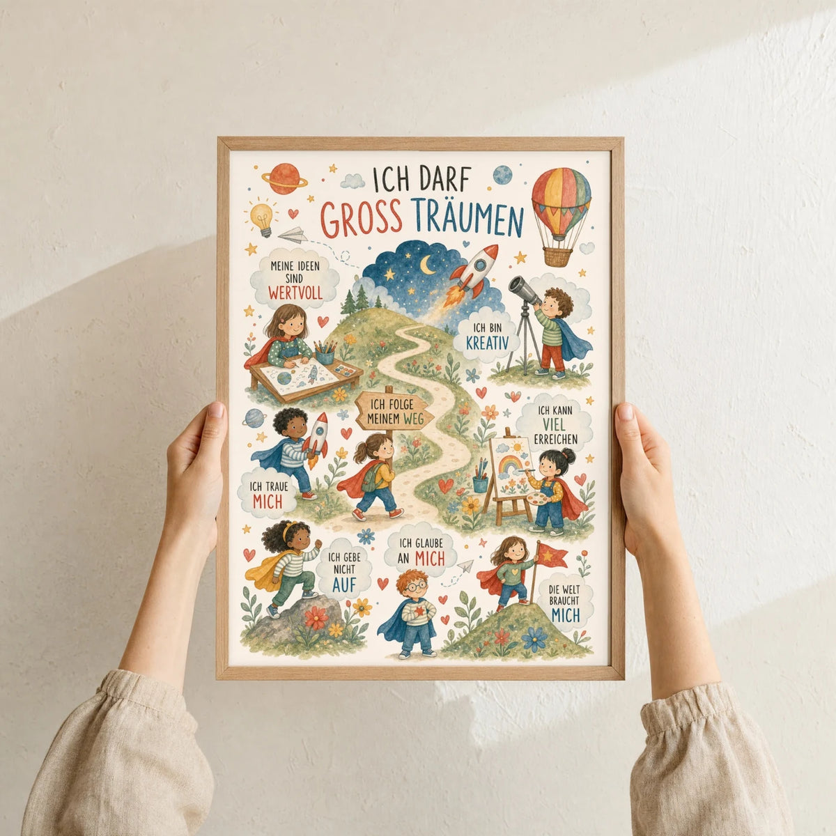 Affirmationsposter „Wimmelbild Groß träumen“ im Holzrahmen in den Händen gehalten – Taufgeschenk und Kinderzimmer Deko